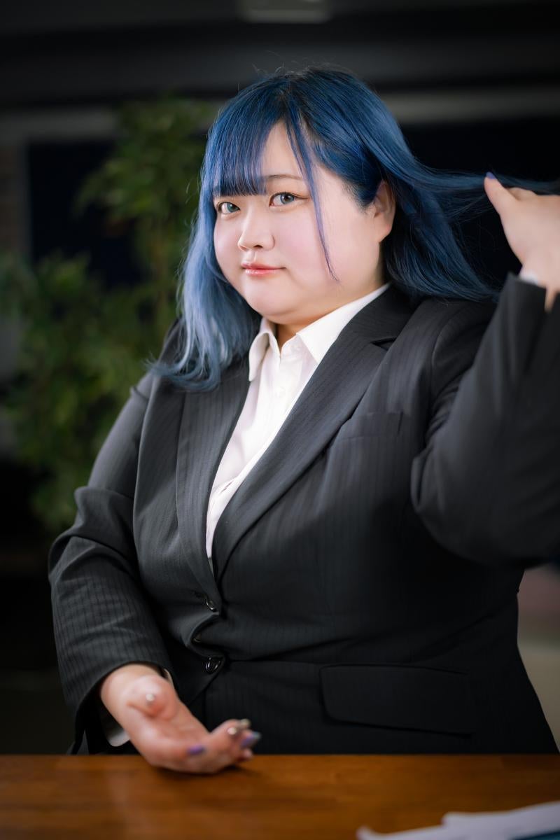 ビジネススーツを着た青髪の女性の写真