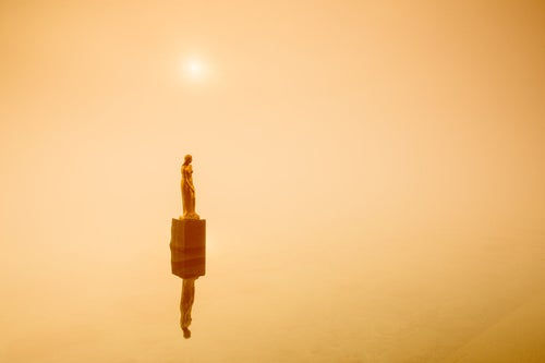 霧に包まれ朝日を浴びるたつこ像の写真