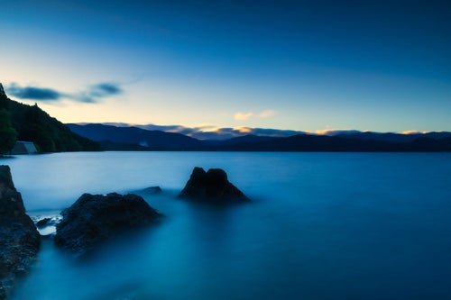 青い田沢湖の朝の写真