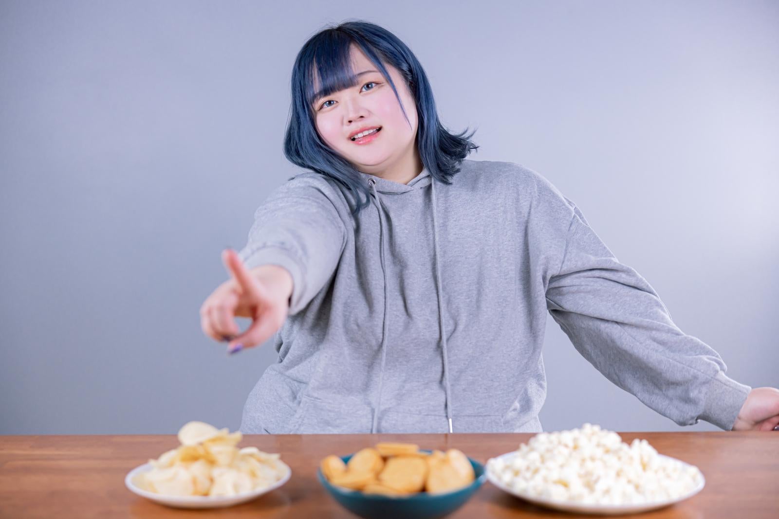 「お菓子を指さしておねだりぽっちゃり女子」の写真［モデル：あねちゃん］