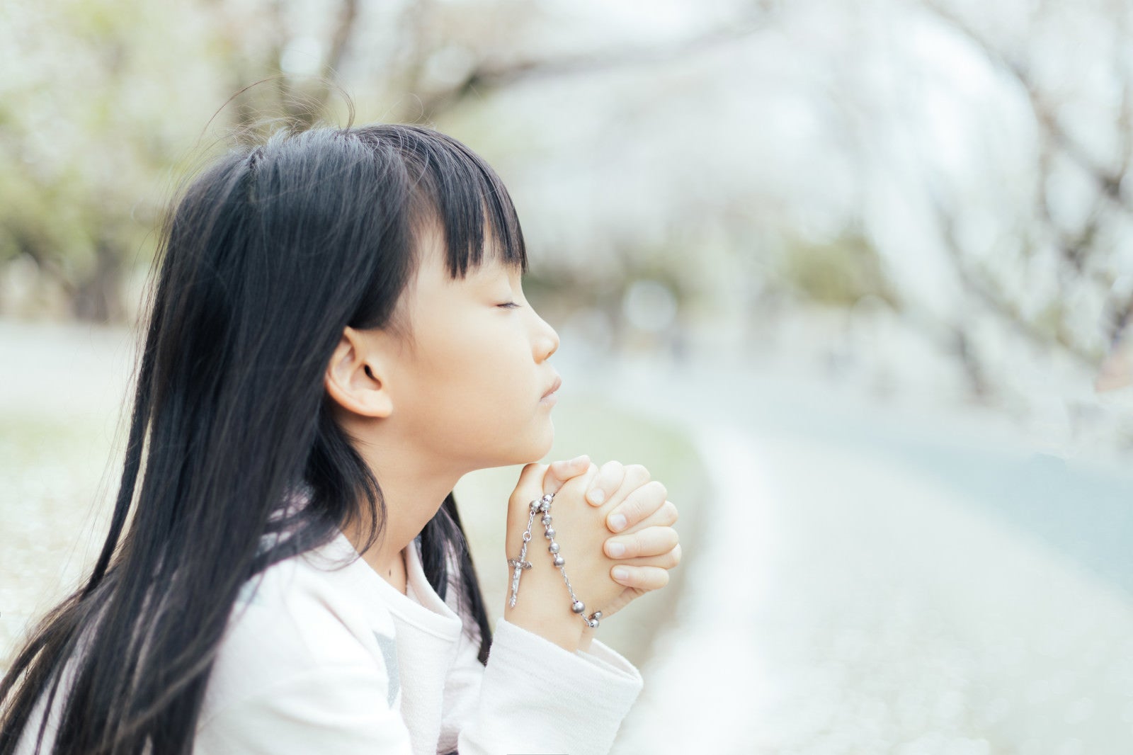 「ロザリアを握り祈るクリスチャンの子供」の写真［モデル：あんじゅ］