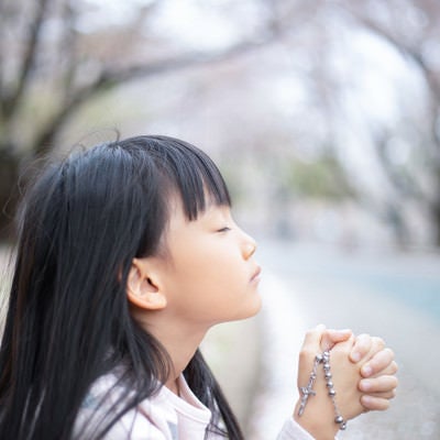 神様に祈りを捧げる女の子の写真