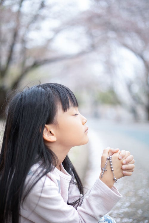 神様に祈りを捧げる女の子の写真
