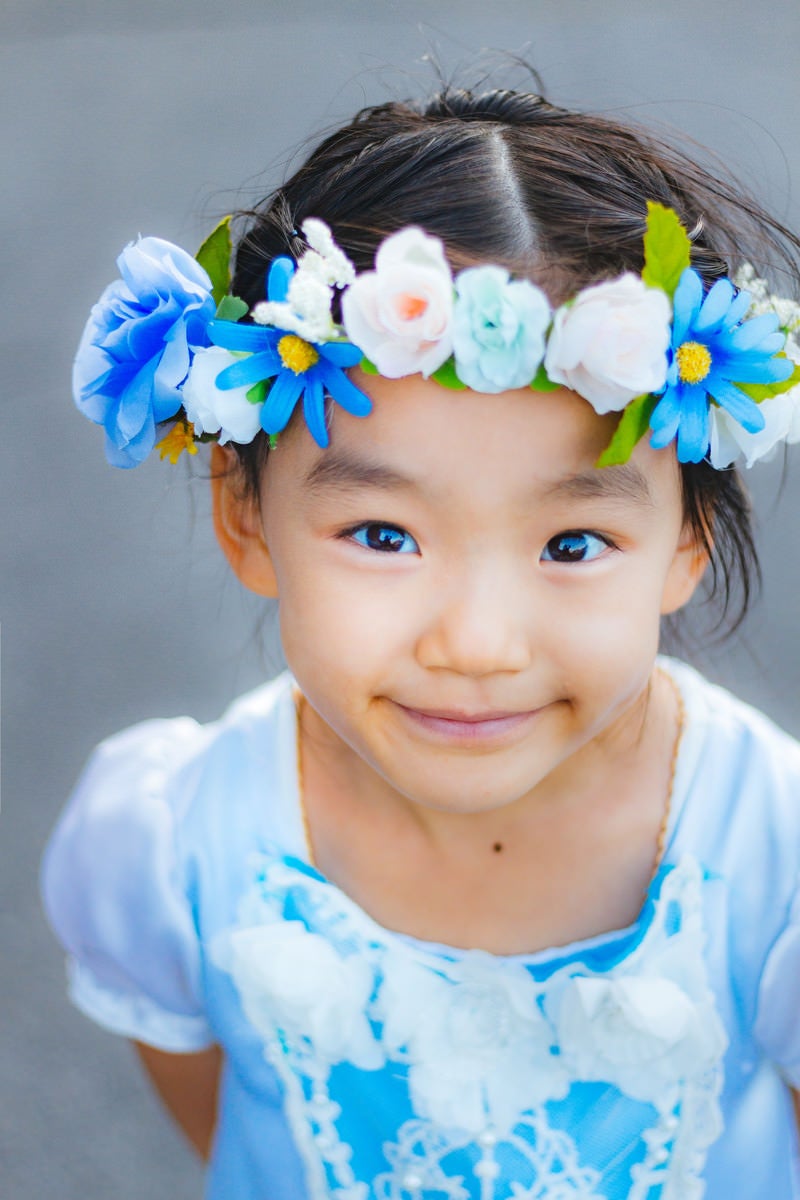 「花飾りを着けたにっこり笑顔の女の子」の写真［モデル：あんじゅ］
