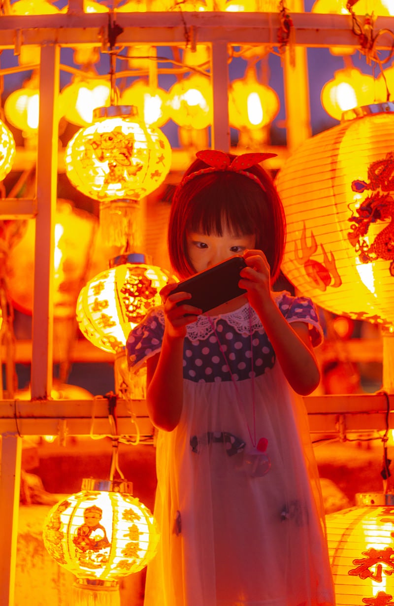 「お祭りの提灯とスマホに夢中の女の子」の写真［モデル：あんじゅ］