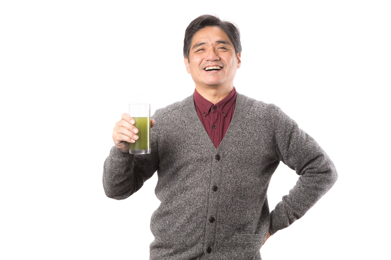 「野菜不足を補う青汁を笑顔で紹介する中年男性」の写真［モデル：よたか］