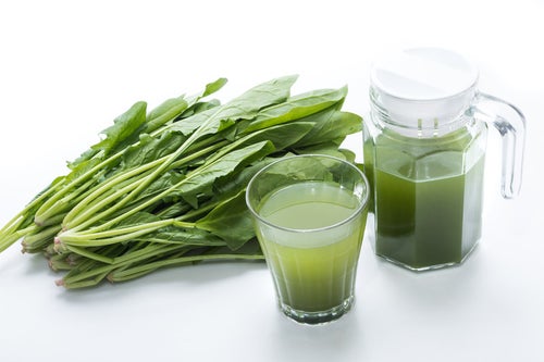 葉物野菜と青汁のグラスの写真