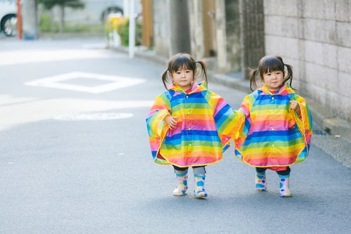 仲良く手をつないで散歩する双子の姉妹（2歳）の写真