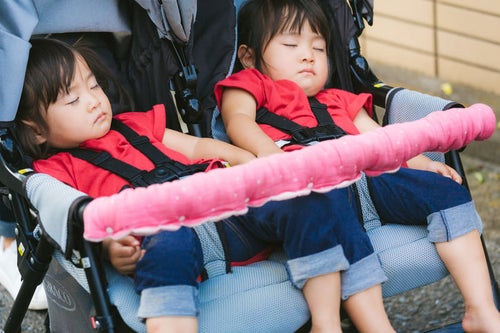 ベビーカーの上で寝てしまった双子女児の写真