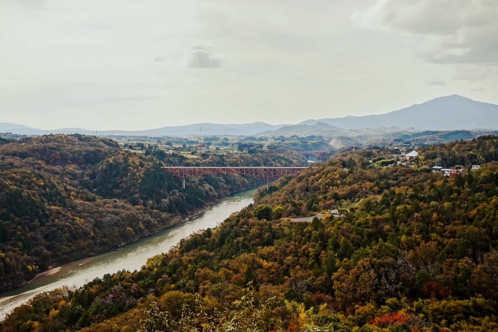 「秋の橋を渡る時 木々の間の色と光」の写真