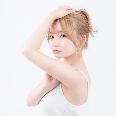 しなやかな腕のラインを魅せるキャミソール姿の女性の写真