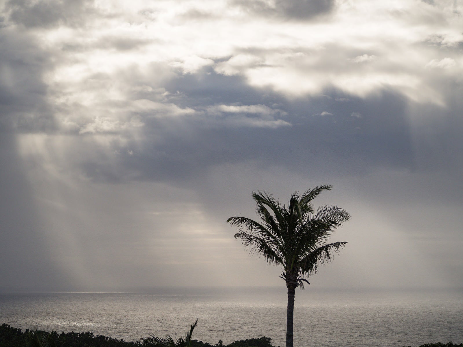 「硫黄島から見えた黒い雲から海へと降りる天使の梯子」の写真