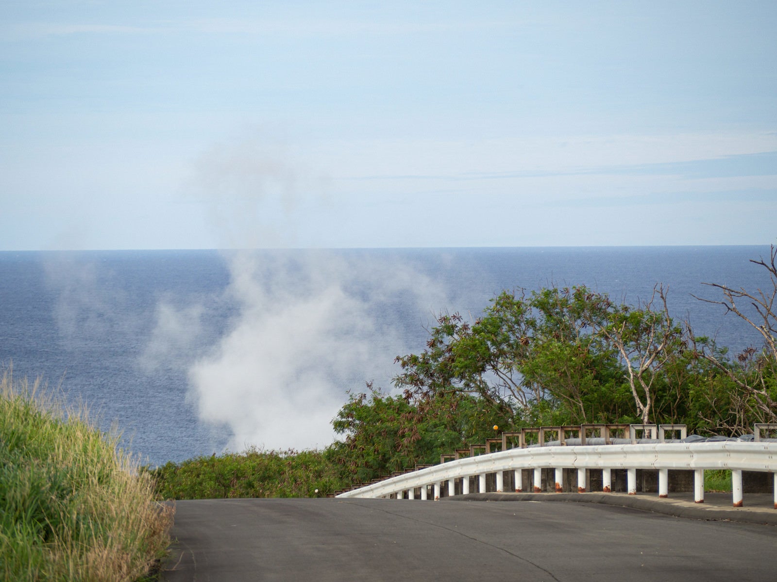 「海へと続く道から見える鶯地獄から上がる蒸気」の写真