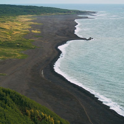 摺鉢山から見える黒々とした砂浜の上陸海岸（二ツ根浜（手前）と翁浜（奥））の写真
