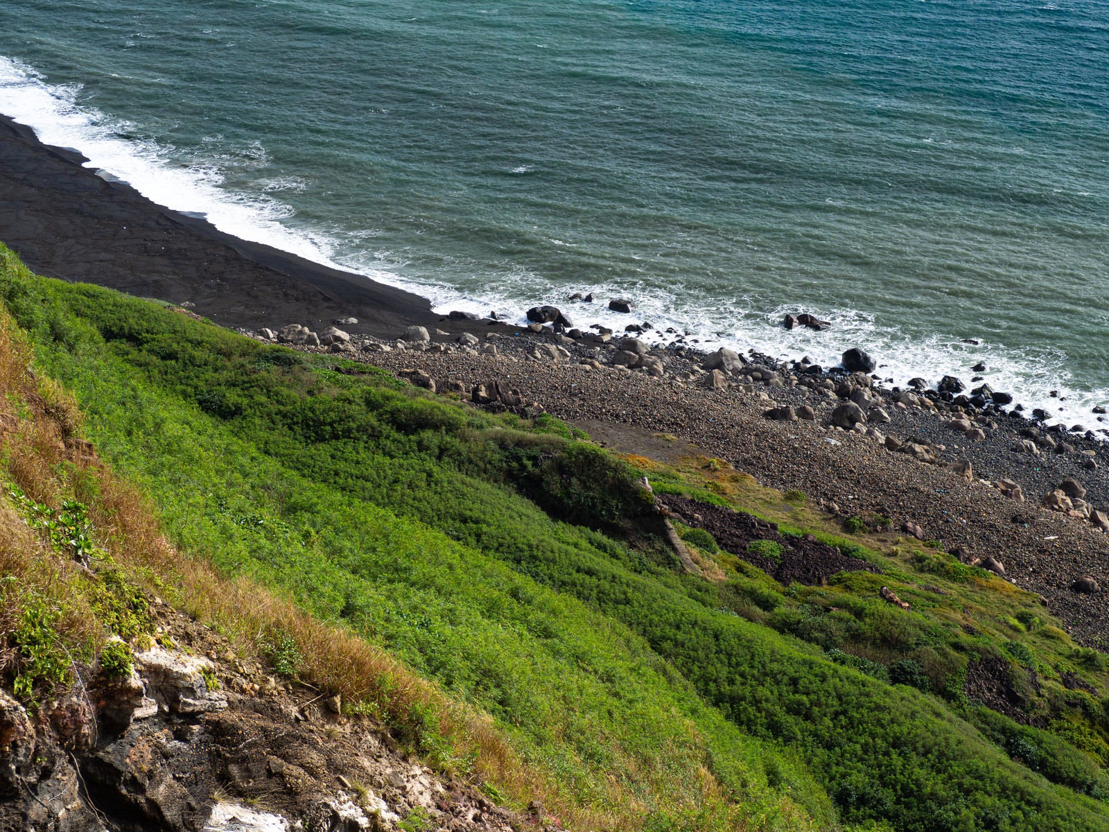 「摺鉢山の眼下に見える崖下に寄せる波」の写真