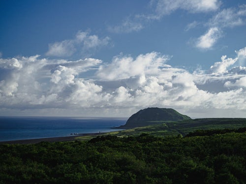 霞んで見える摺鉢山と翁浜（上陸海岸）の写真