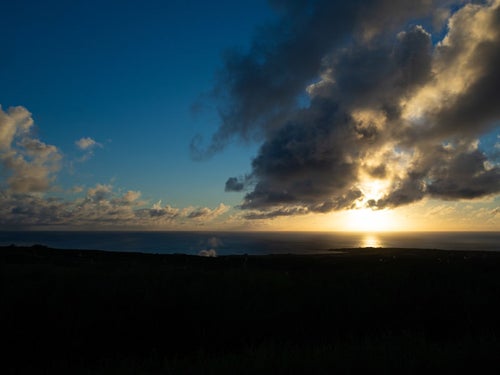 摺鉢山と千鳥ヶ浜の向うに見える夕陽に輝く雲の写真