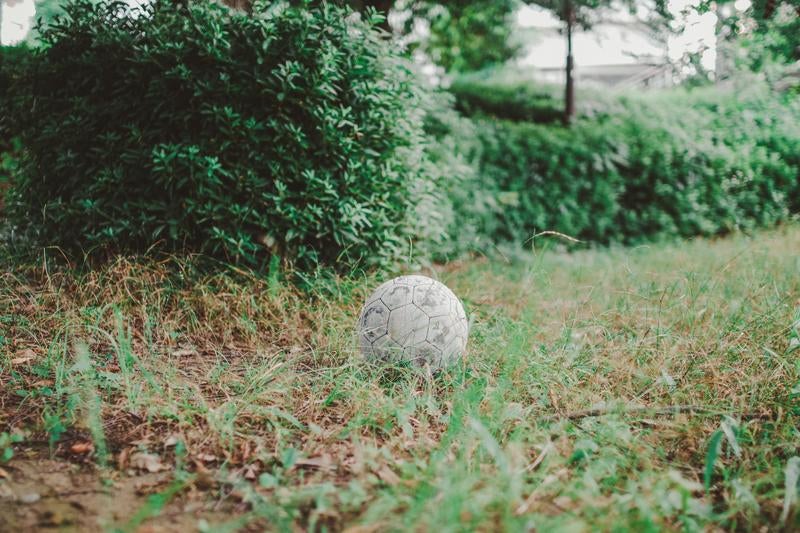 公園に放置されたサッカーボールの写真
