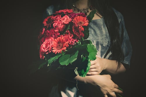 バラの花束をを抱えた女性の写真