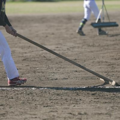 トンボでグラウンド整備をする人の写真
