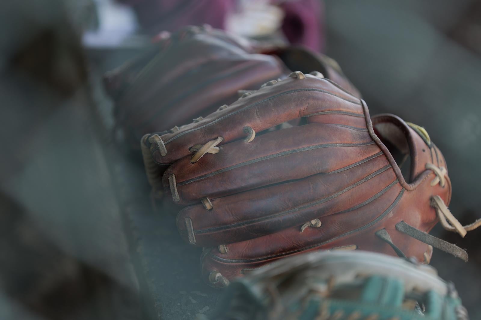 使い込まれた茶色の革製野球グローブのクローズアップ