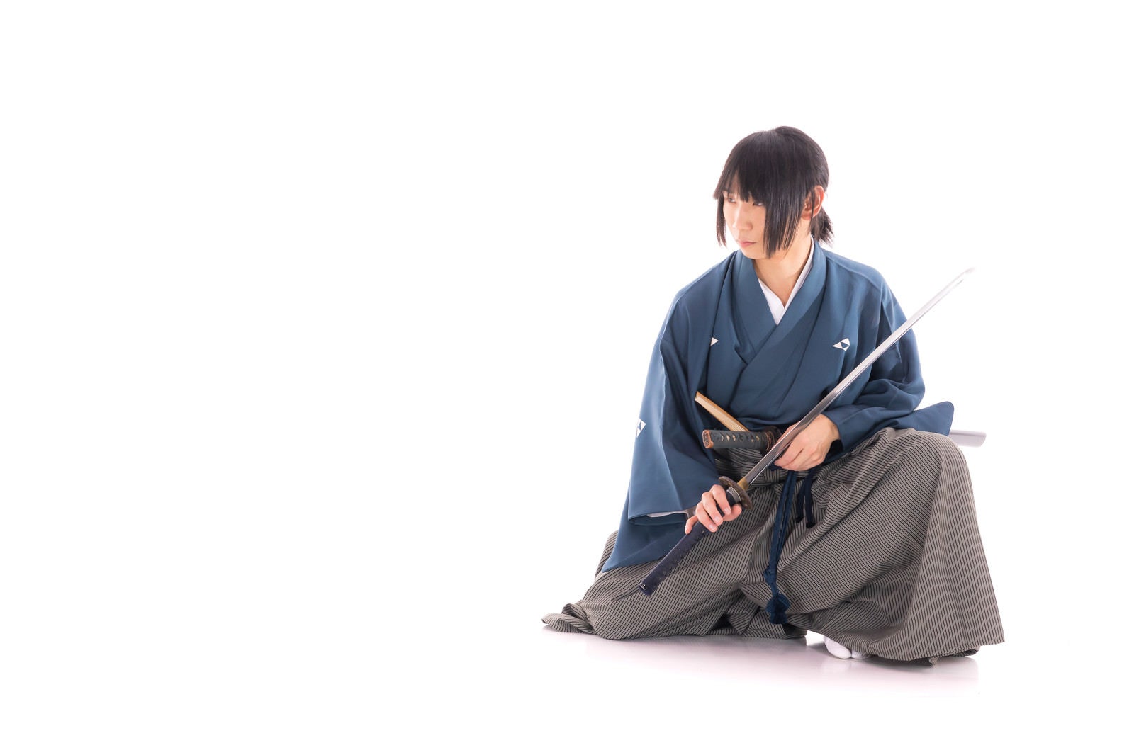 「座った状態で刀を納める侍」の写真［モデル：まーこ］