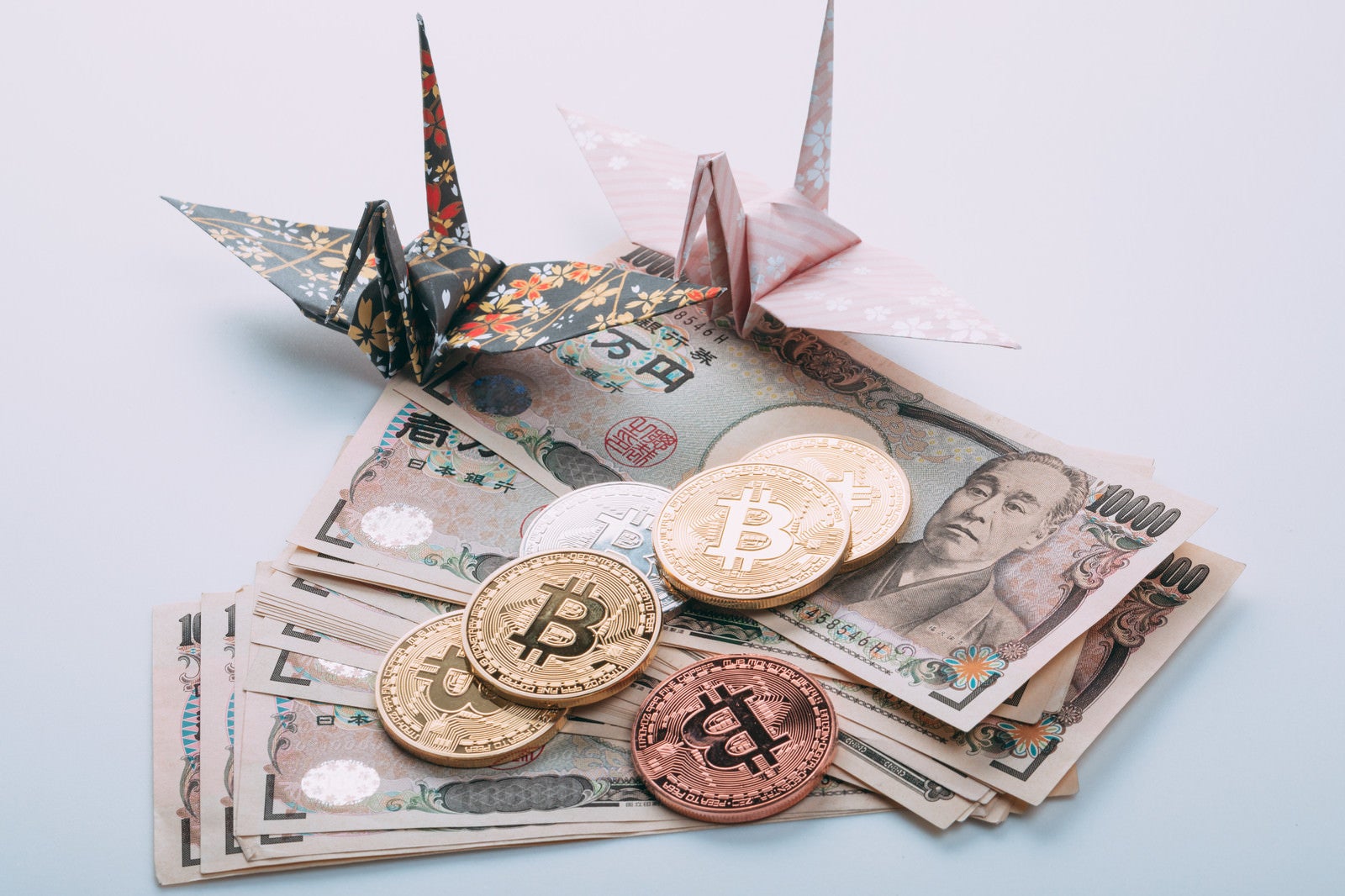 「折り鶴とビットコインと日本円（1万円札）」の写真