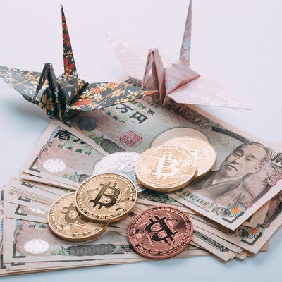 折り鶴とビットコインと日本円（1万円札）の写真