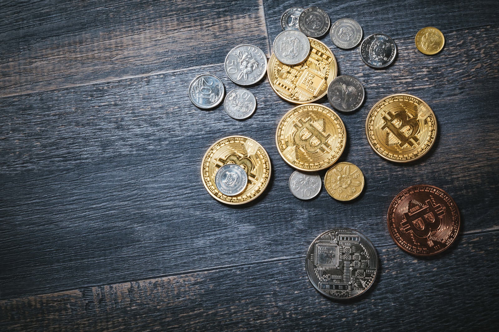 「散らばったビットコインと貨幣」の写真