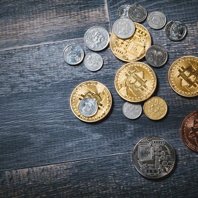 散らばったビットコインと貨幣の写真