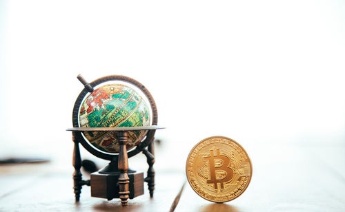 地球儀とビットコインの写真