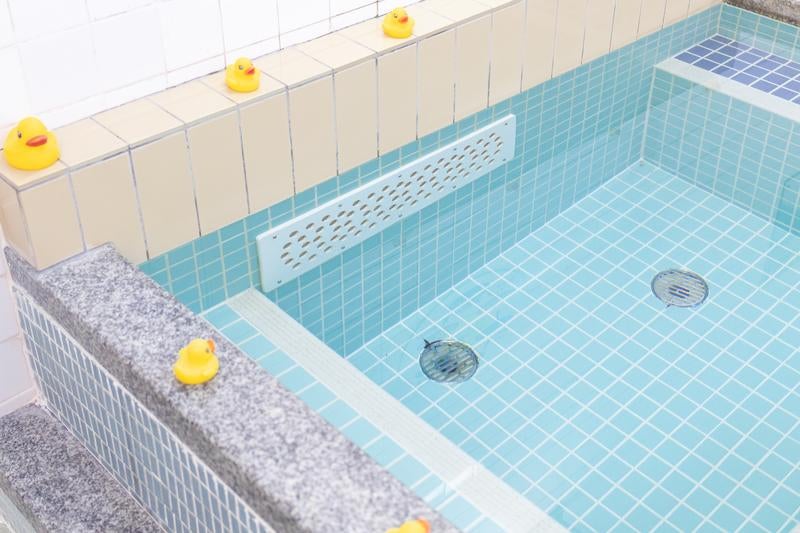 銭湯の浴槽に並ぶアヒルのおもちゃ