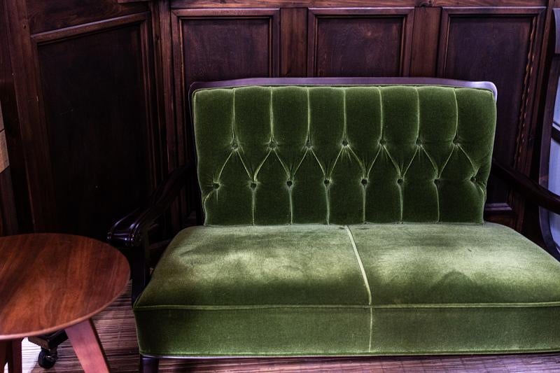 緑のベルベットソファーとサイドテーブル