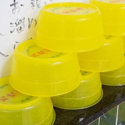 積み重なる銭湯の黄色い湯桶の写真