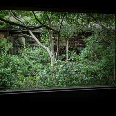窓から見える廃屋敷の写真
