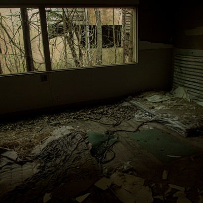 ボロボロに剥がれた廃部屋とマットの写真