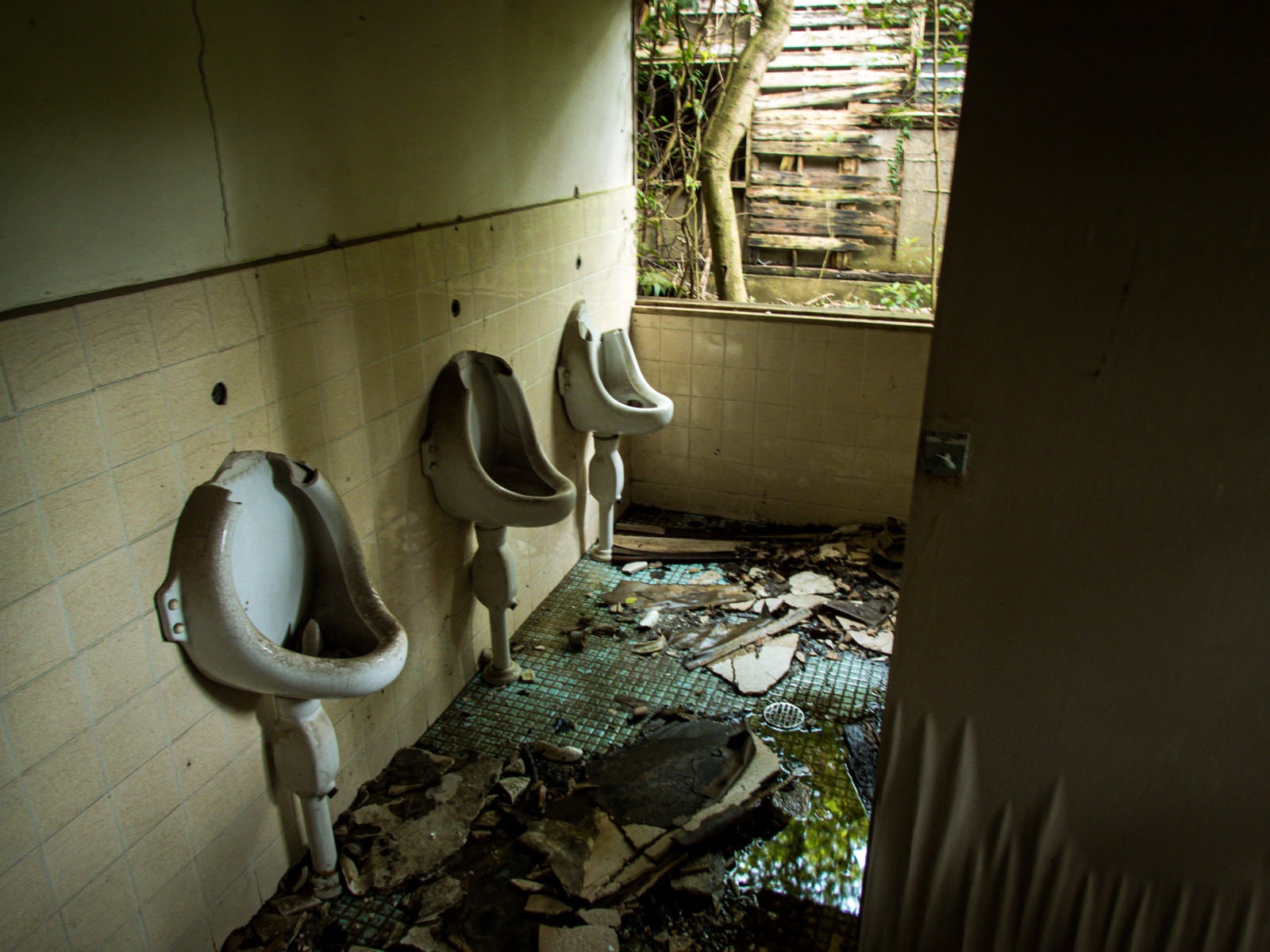 「ぼろぼろに朽ち果てたトイレ（男性用）」の写真