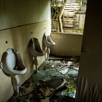 ぼろぼろに朽ち果てたトイレ（男性用）の写真