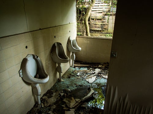 ぼろぼろに朽ち果てたトイレ（男性用）の写真