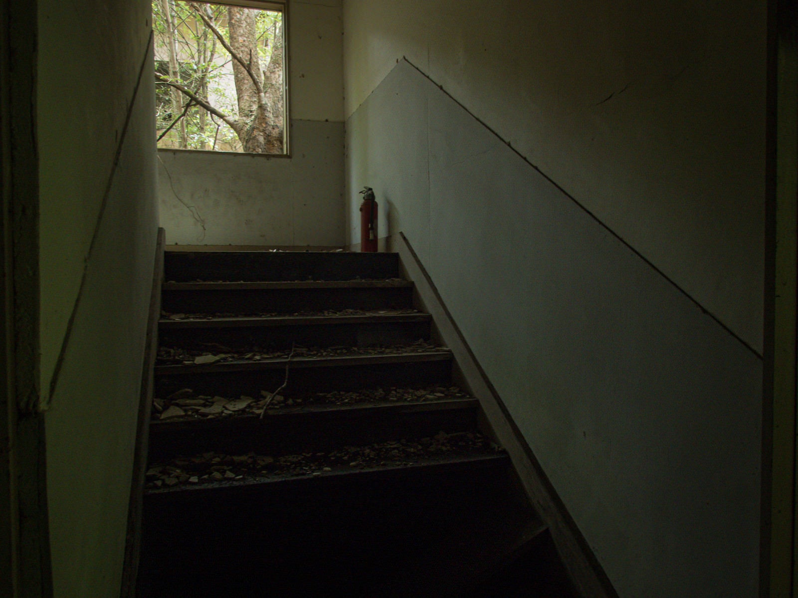「廃墟の階段とその上にある消化器」の写真