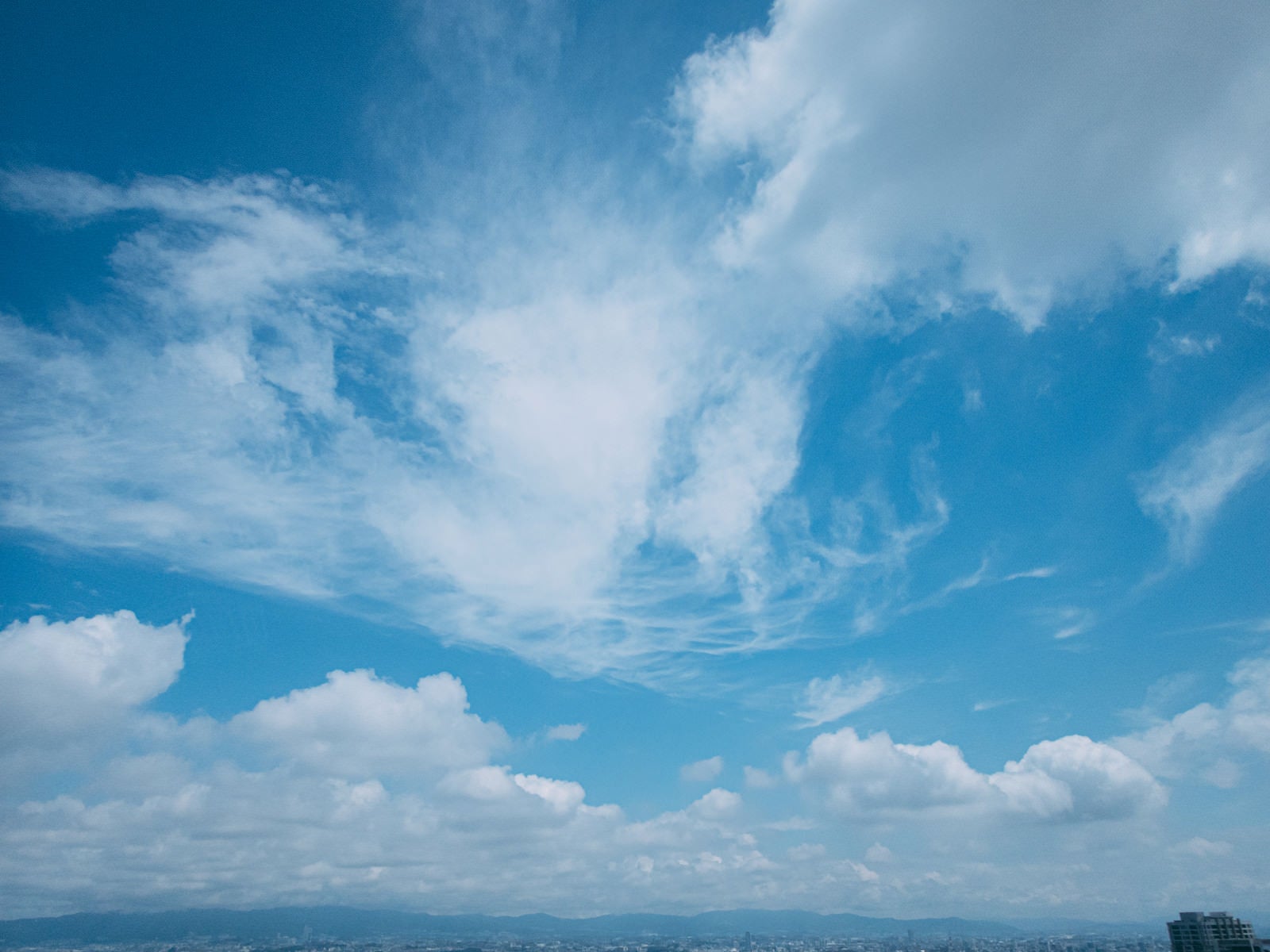 「上空を流れる様々な形の雲」の写真