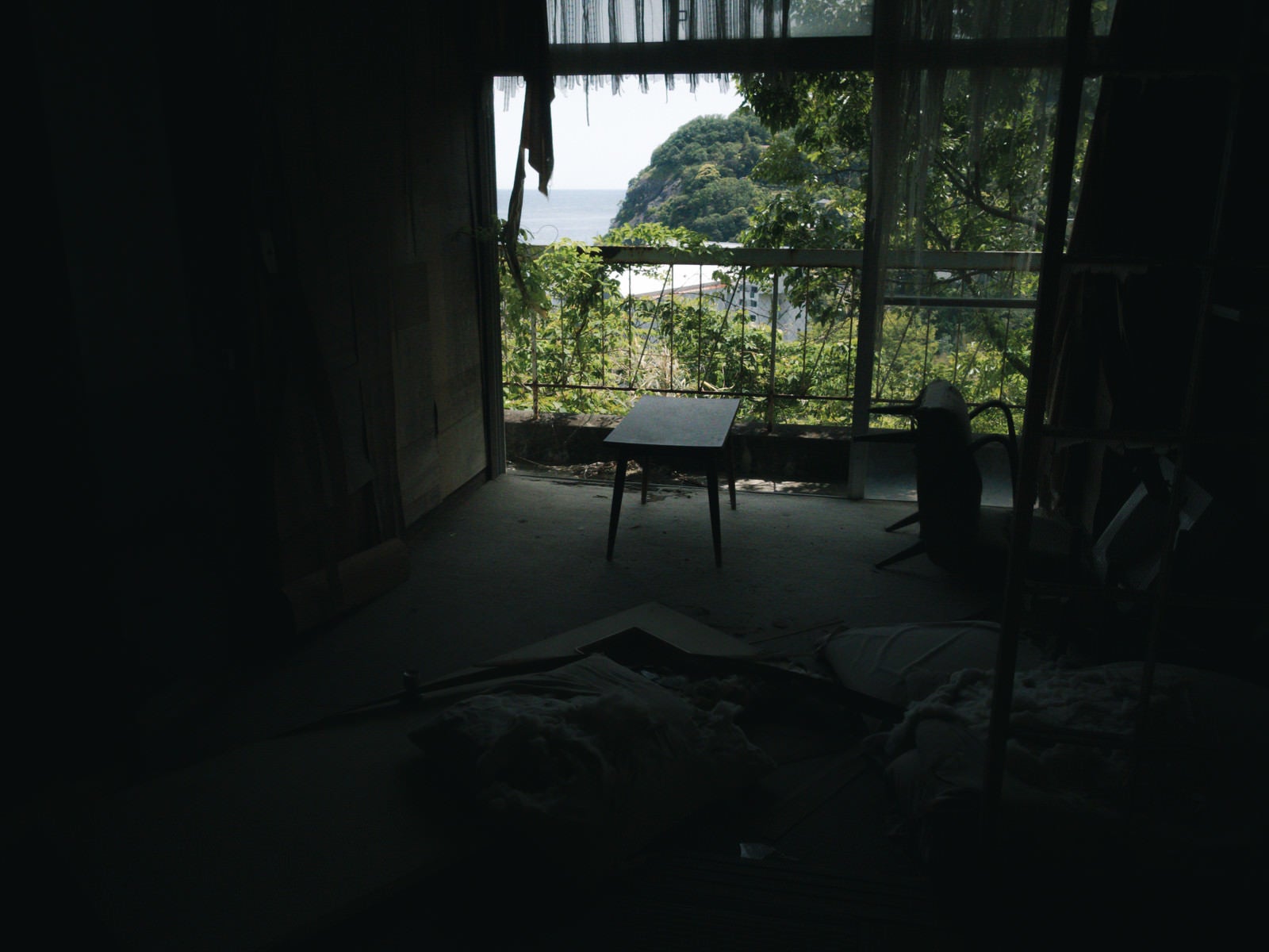 「廃屋の窓辺に置かれた机」の写真