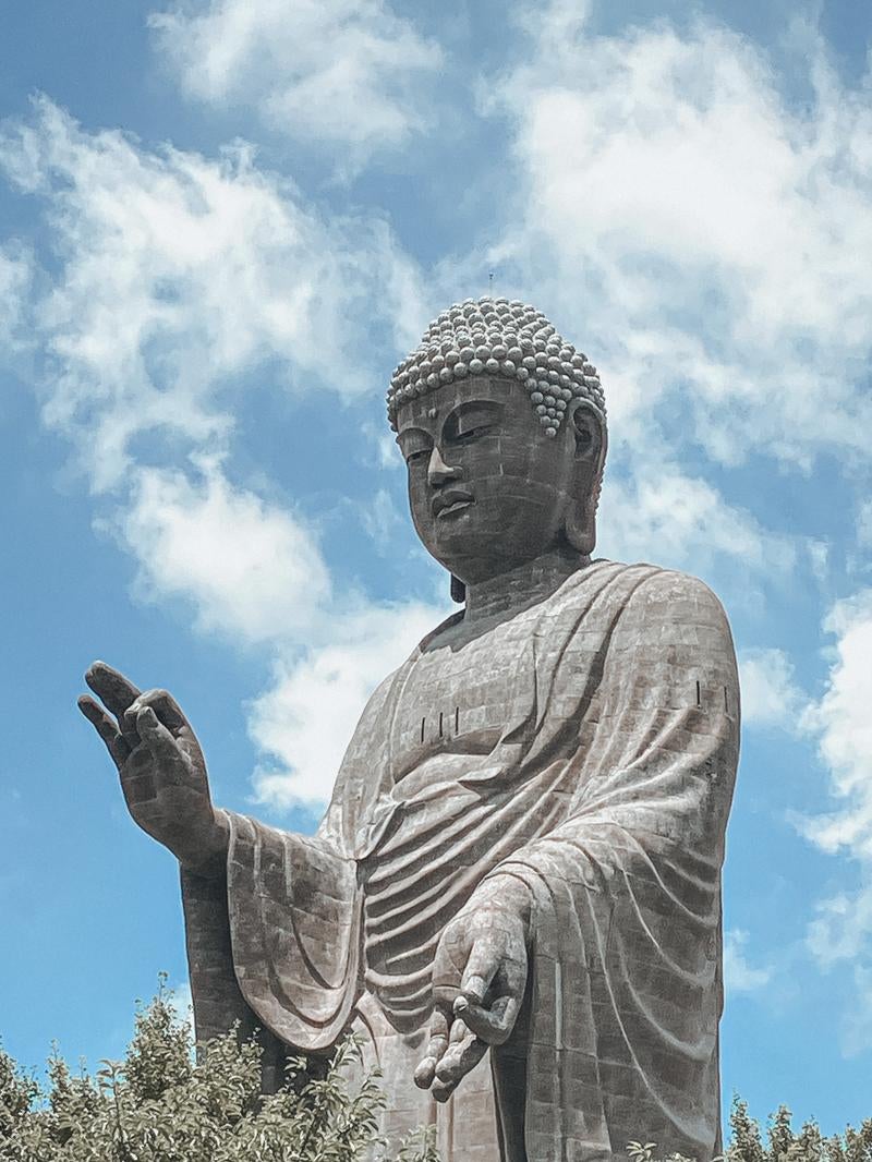 青空の下にそびえる巨大な牛久大仏の写真