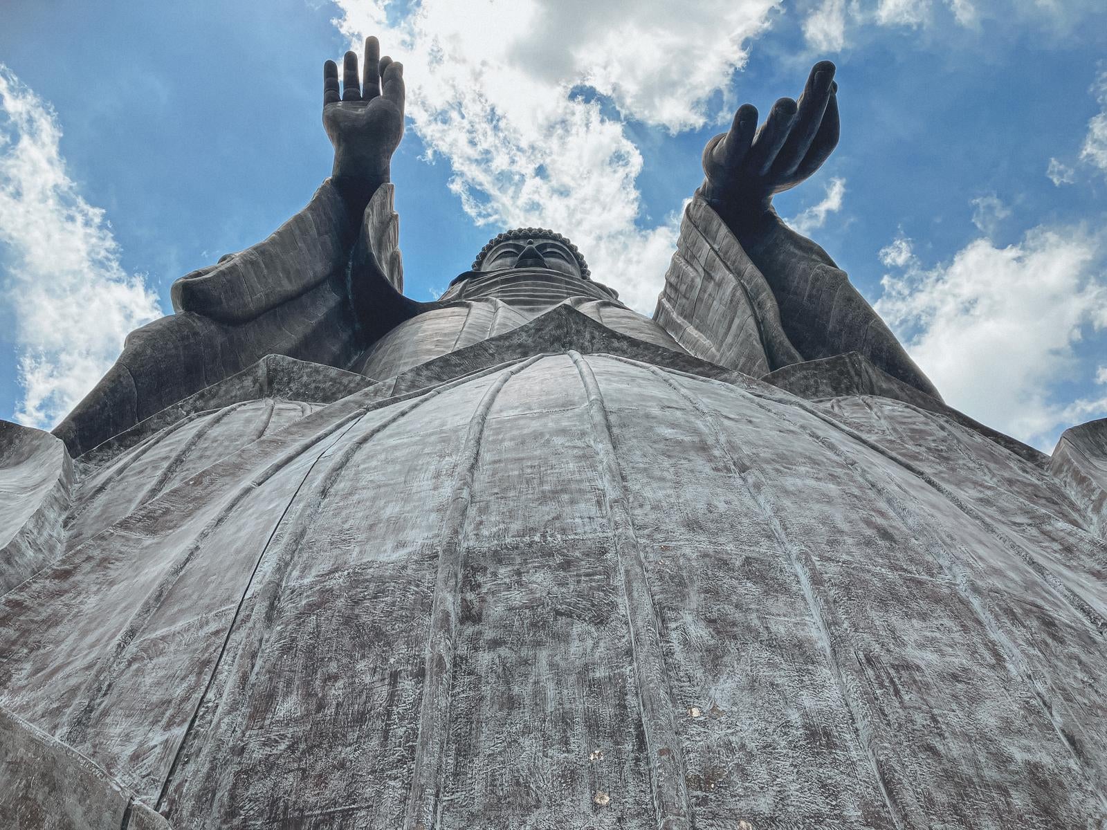 「天空に向かって両手をあげる牛久大仏の姿」の写真