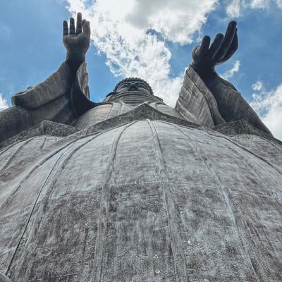天空に向かって両手をあげる牛久大仏の姿の素材