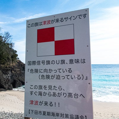 浜辺に掲げられた津波の警告看板の写真