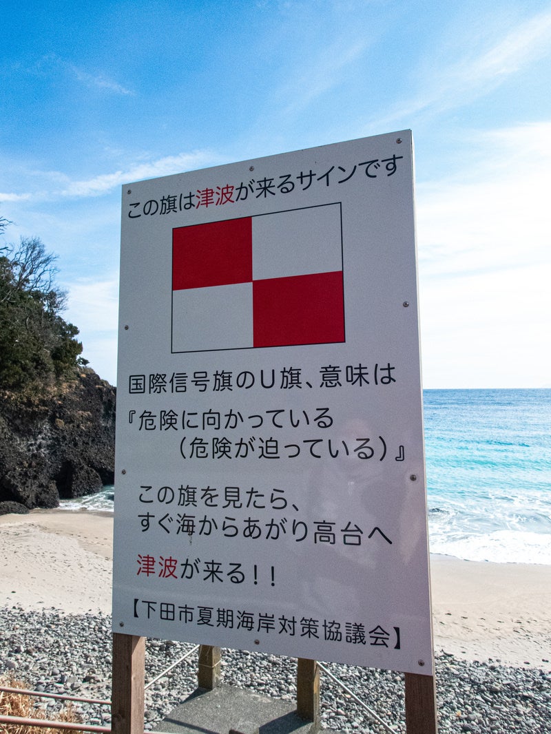 「浜辺に掲げられた津波の警告看板」の写真