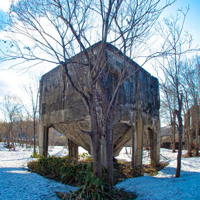 残雪が積もるコンクリート製ホッパーの廃工場の写真