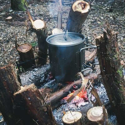 焚き火台で温める鍋の写真