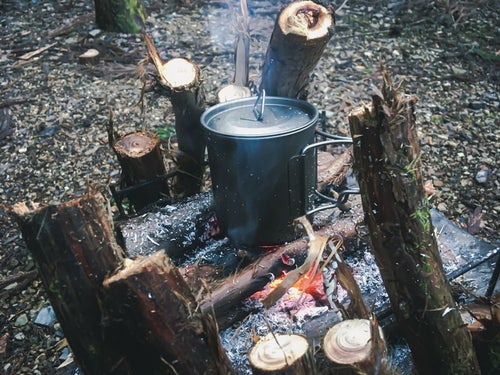 焚き火台で温める鍋の写真